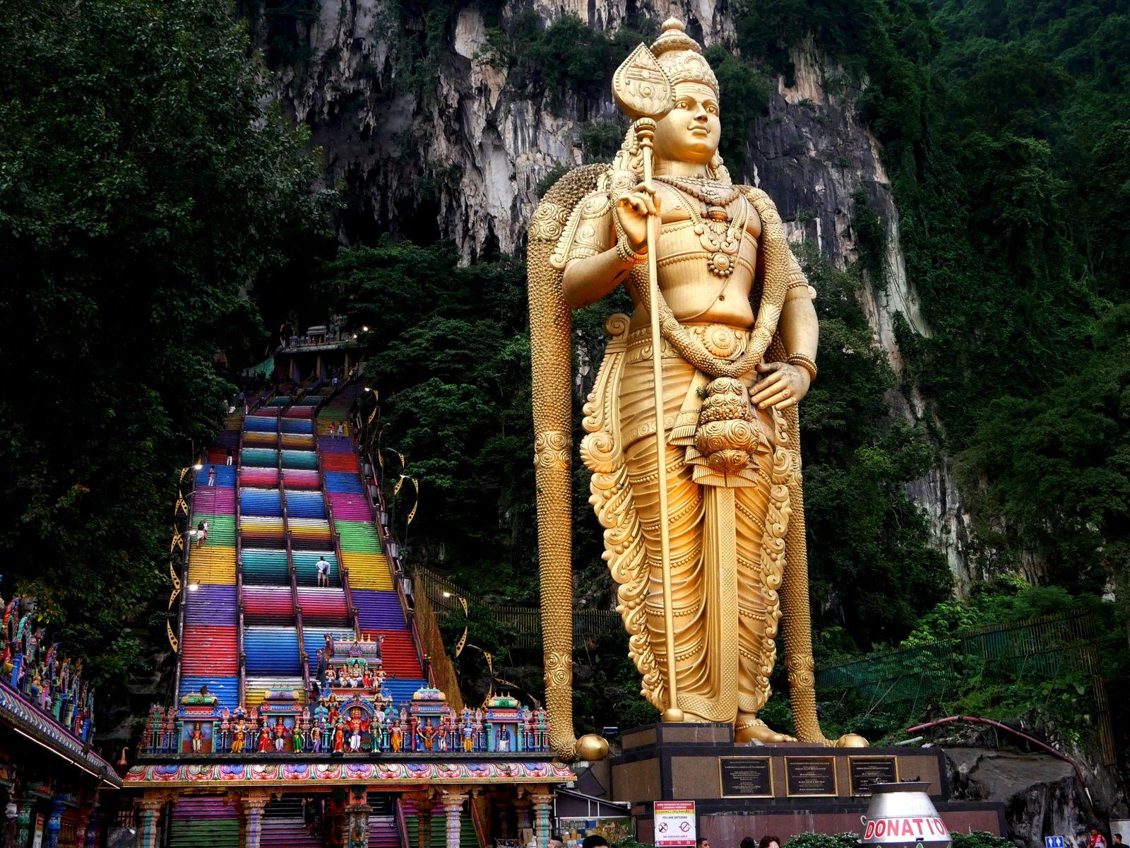 Golden Lord Murugan statue and rainbow stairs at Batu Caves